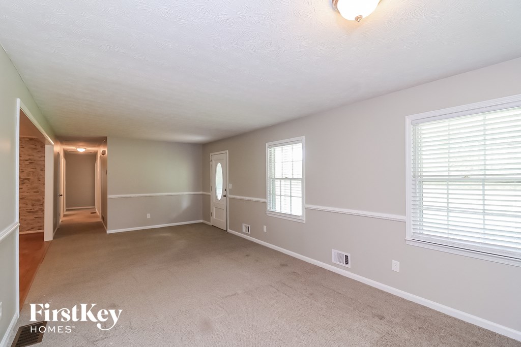 a living room with a carpeted floor and a large window