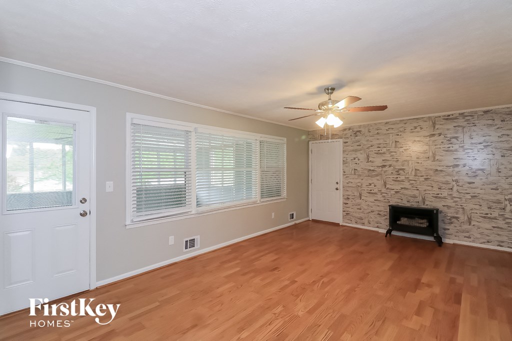 the living room of a house with a brick accent wall and wood floors