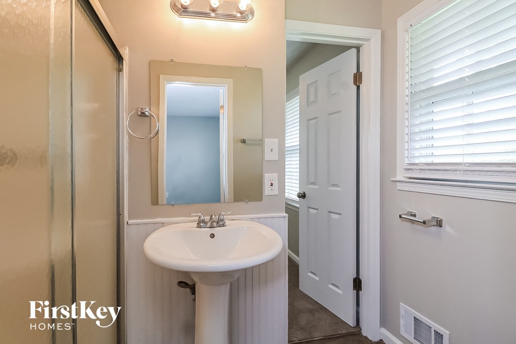 a small bathroom with a sink and a mirror and a shower