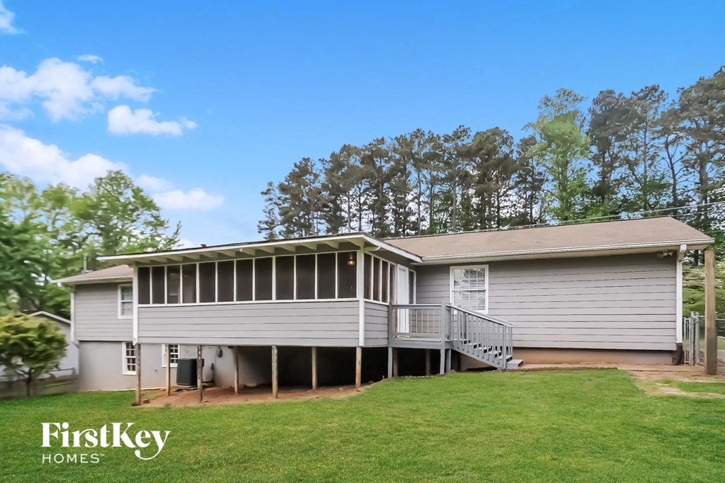 front view of a white house with a porch and a lawn