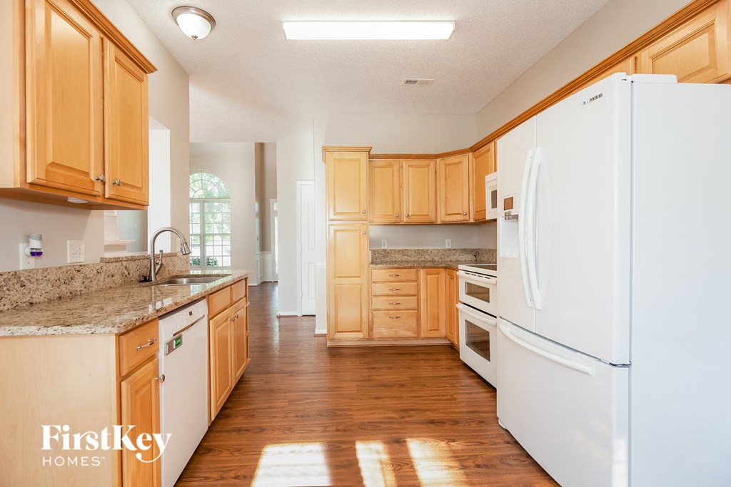 a kitchen with white appliances and wooden cabinets