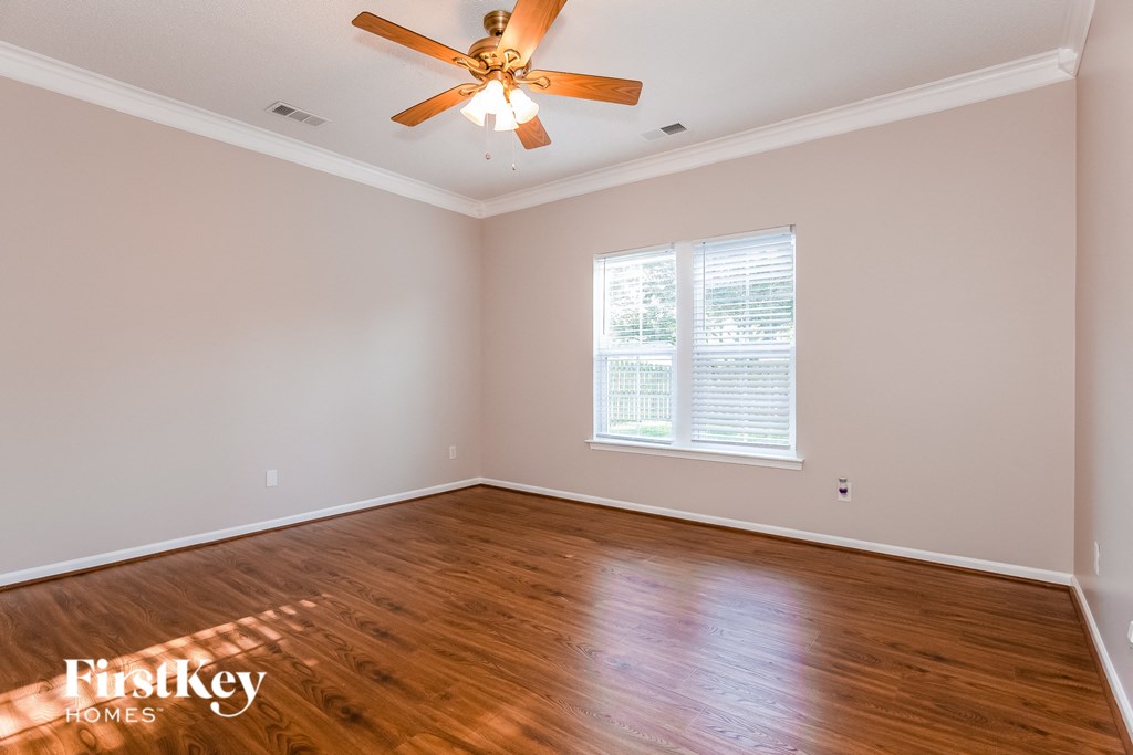 the living room of a home with wood floors and a ceiling fan