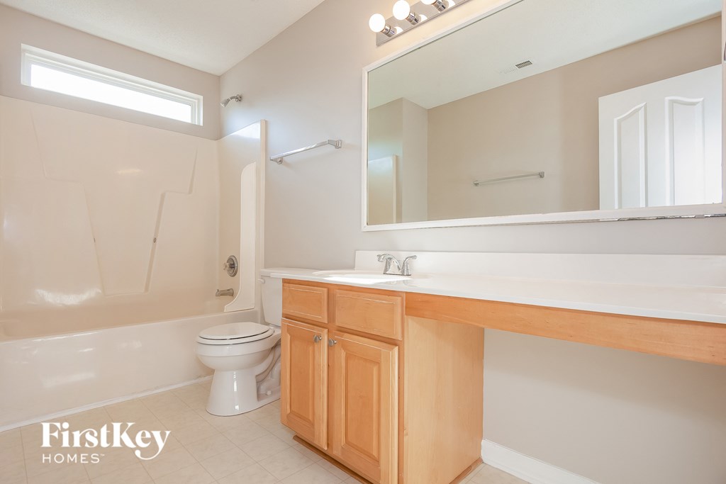 a bathroom with a toilet and a sink and a mirror