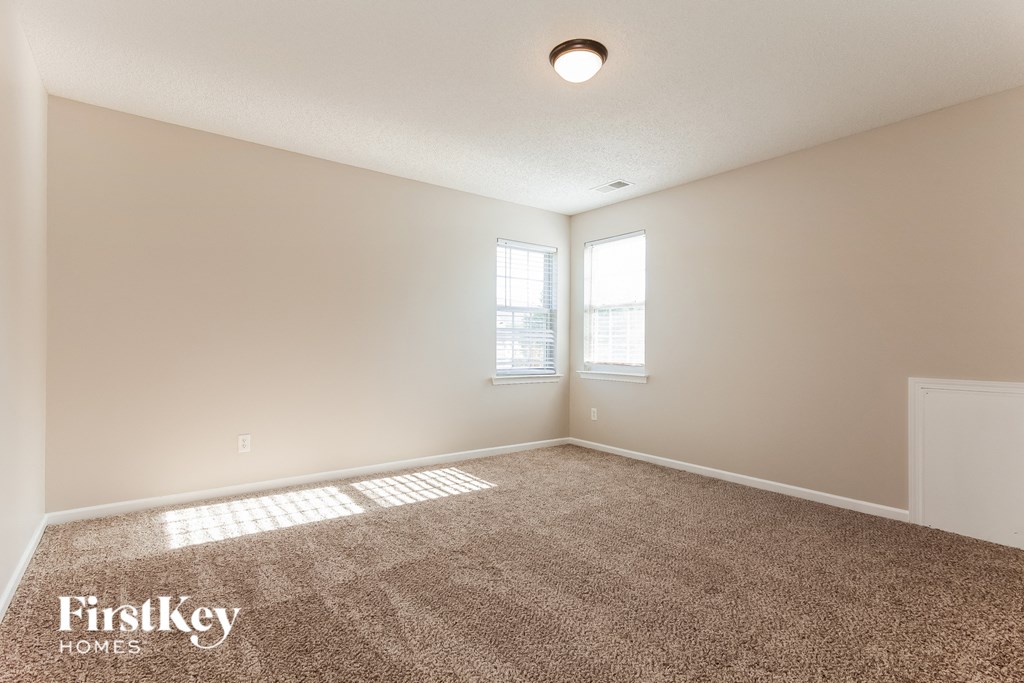 a spacious living room with carpet and a window