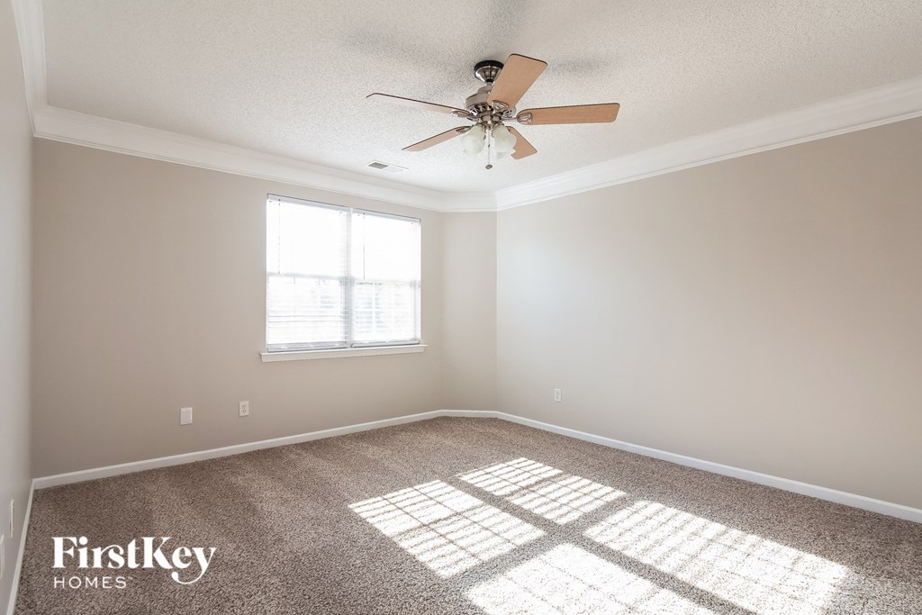 a empty room with a ceiling fan and a window