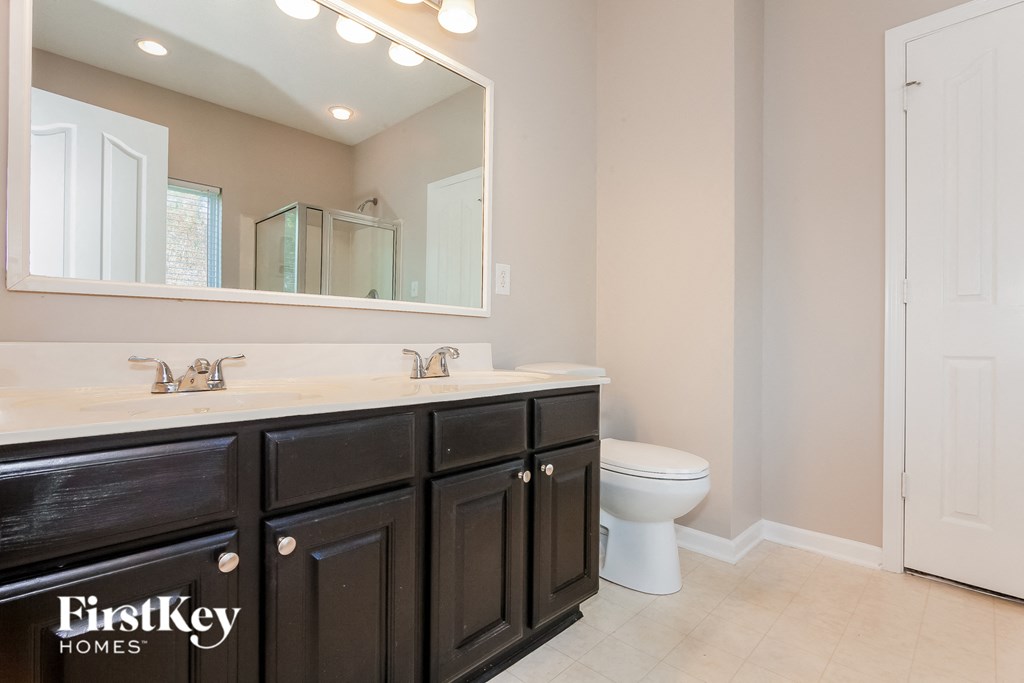 a bathroom with a toilet and a sink and a mirror