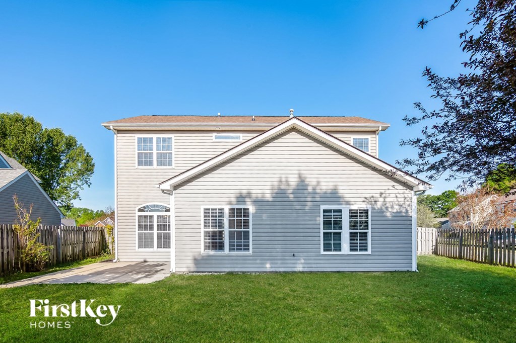 a white house with a yard and a fence