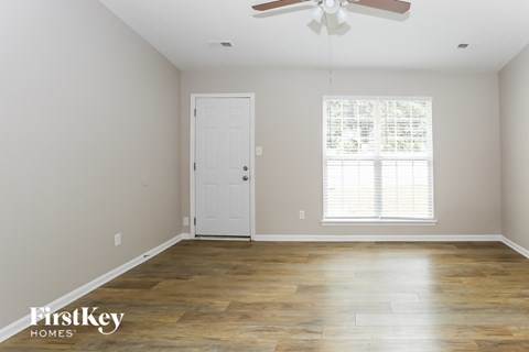a living room with wood floors and a white door
