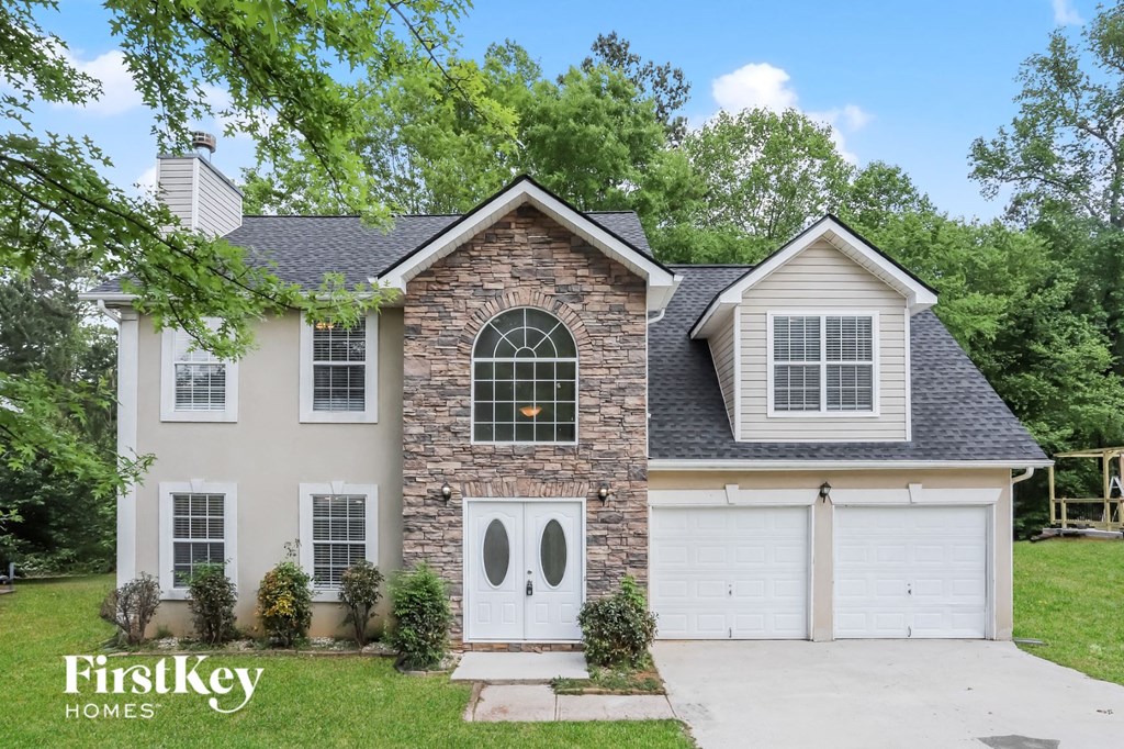 a white house with white doors and a white garage door