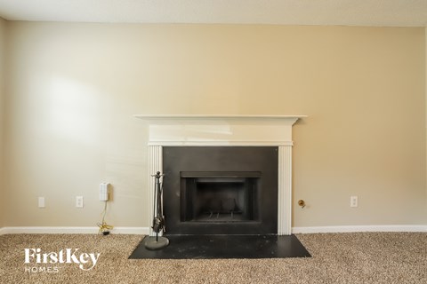 the living room has a fireplace and a carpet