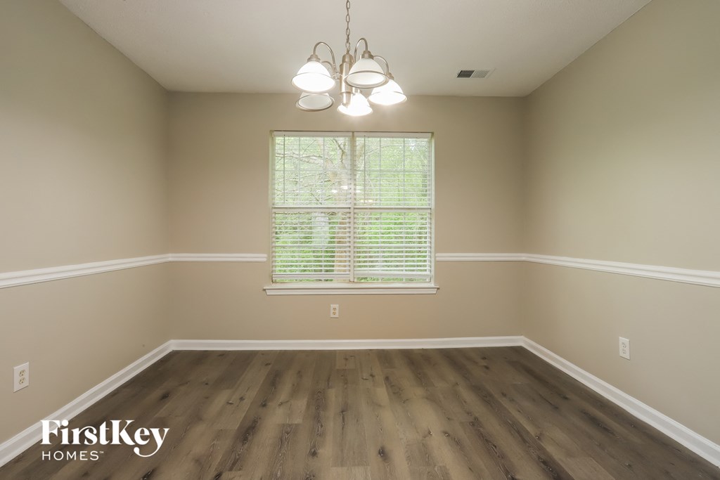 a dining room with a window and wooden floors