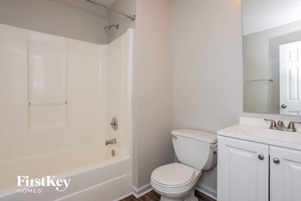 a bathroom with a toilet and a tub and a sink