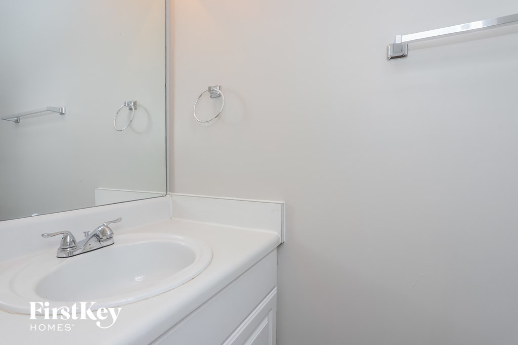 a white bathroom with a sink and a mirror
