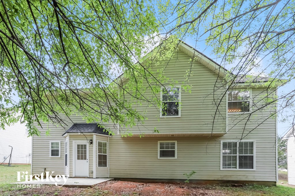 a green house with a tree in front of it