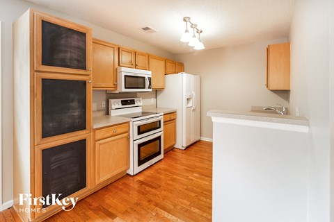 A kitchen with wooden cabinets and a white refrigerator.