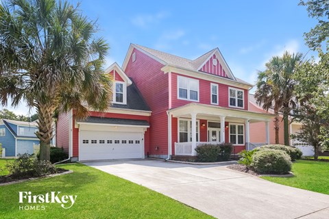 a red house with a garage and palm trees