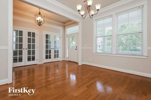an empty living room with a hardwood floor and doors
