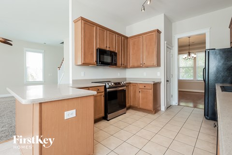 a kitchen with wooden cabinets and a black stove and a microwave