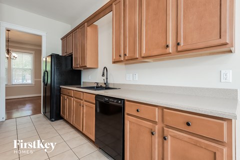 a kitchen with wooden cabinets and a black dishwasher