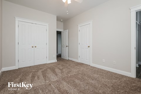 a bedroom with two closets and a carpeted floor