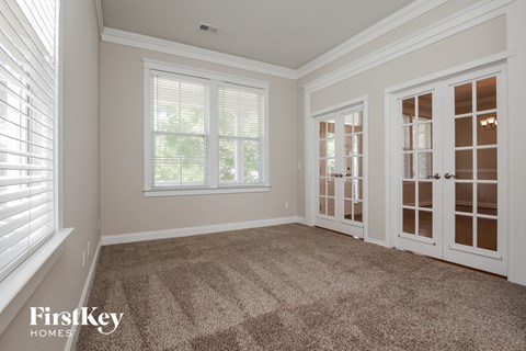 a living room with carpet and doors