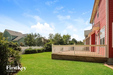 a backyard with a wooden deck next to a house