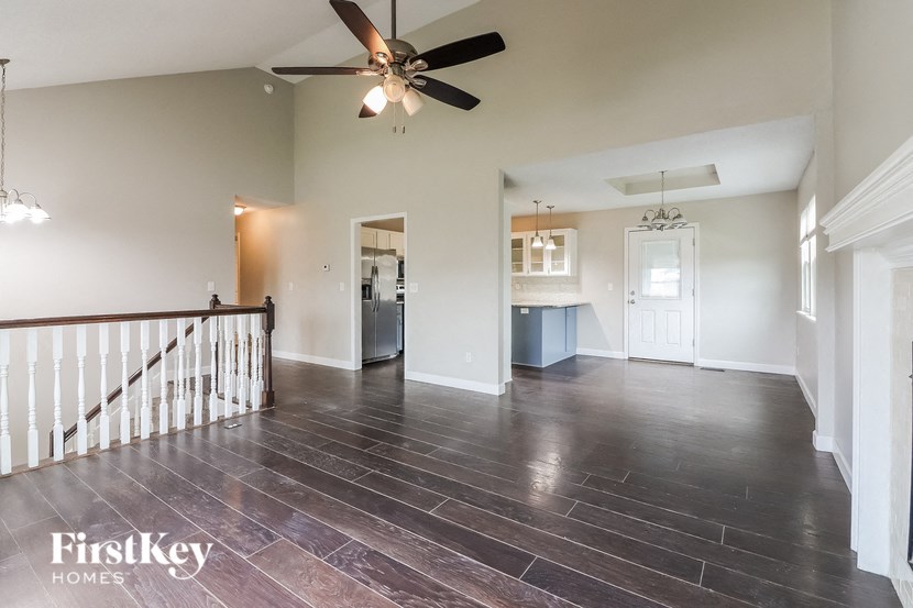 a living room with a staircase and a ceiling fan