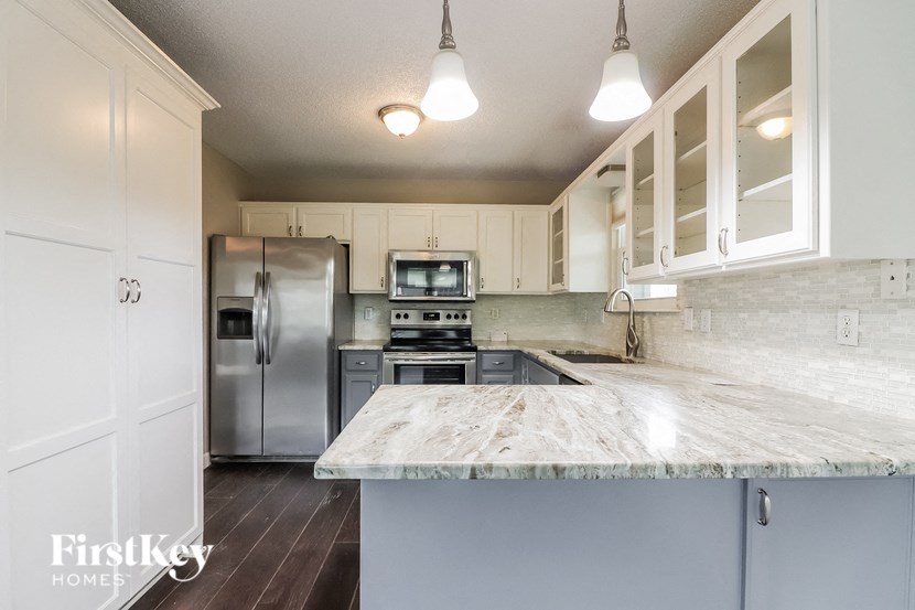 a kitchen with a marble counter top and stainless steel appliances