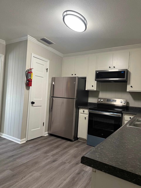 A kitchen with a stainless steel refrigerator and oven.