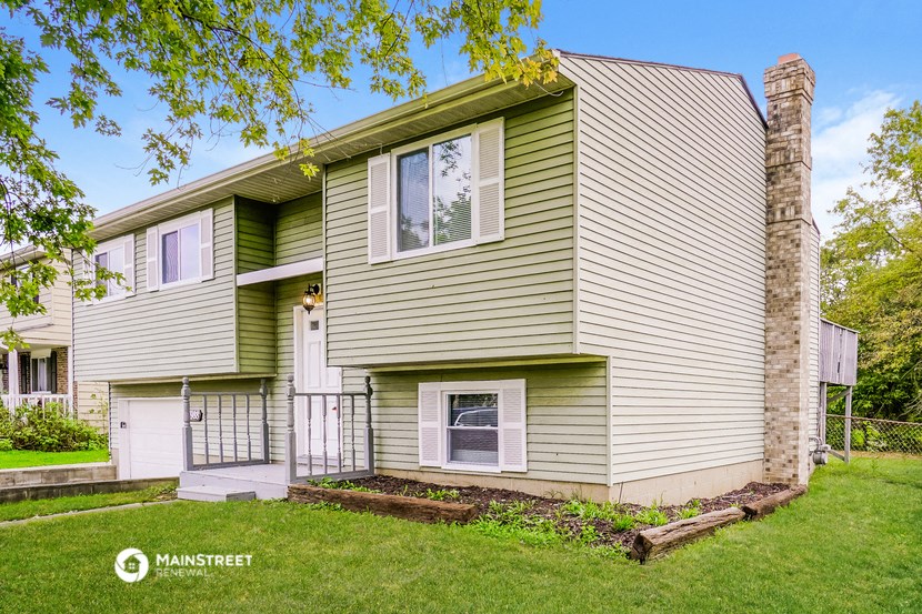 a green and white house with a yard and grass