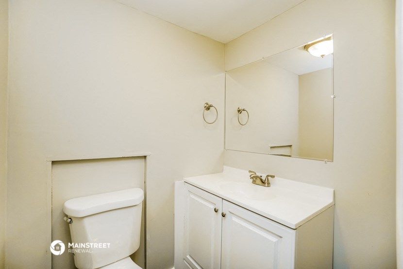 a bathroom with a toilet and a sink and a mirror
