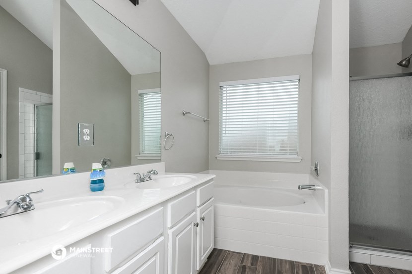 a bathroom with two sinks and a tub and a mirror