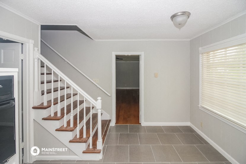 the entryway of a house with stairs and a door to a hallway and a