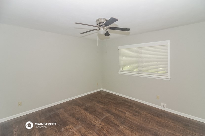 a bedroom with a ceiling fan and a window