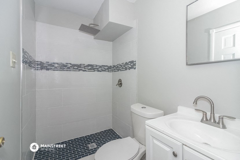 a white bathroom with a sink toilet and shower