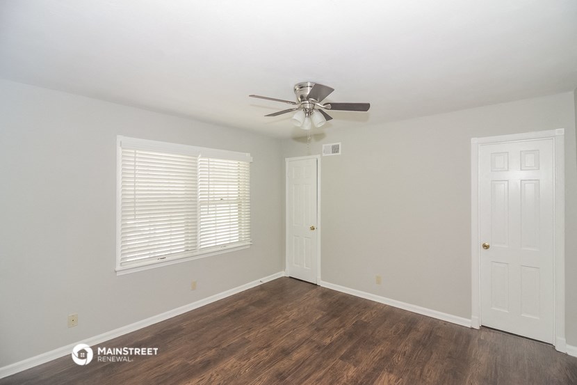 a bedroom with a ceiling fan and a door