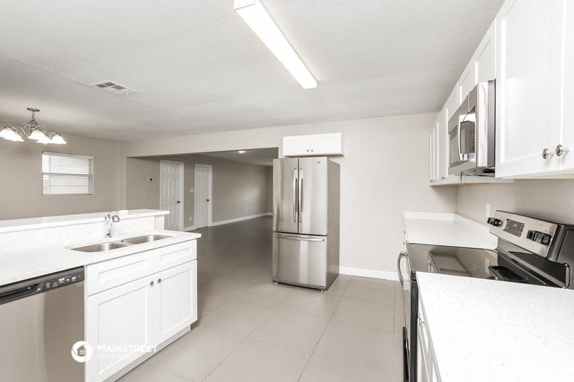 a kitchen with white cabinets and stainless steel appliances