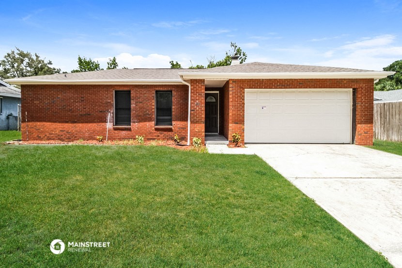 a brick house with a white garage door and a lawn