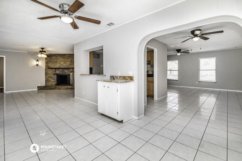a kitchen and living room with tile flooring and a fireplace