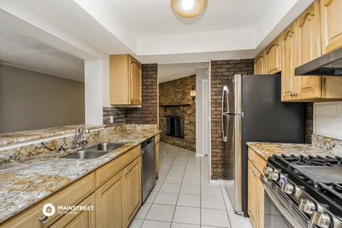 a kitchen with wooden cabinets and granite counter tops and a brick fireplace