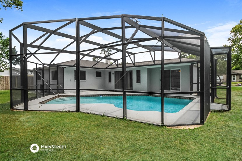 a pool in the backyard of a house with a screened in pool