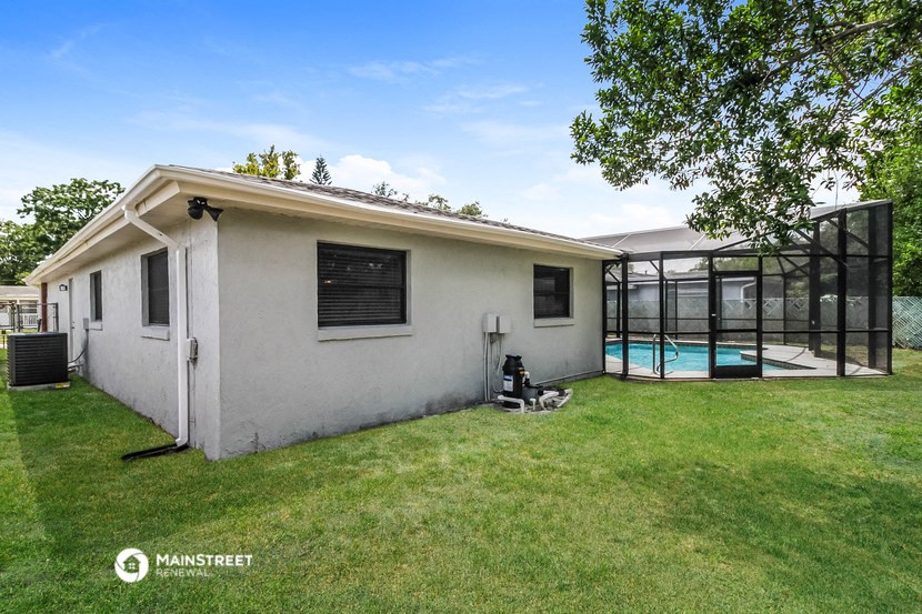 a small white house with a backyard and a pool