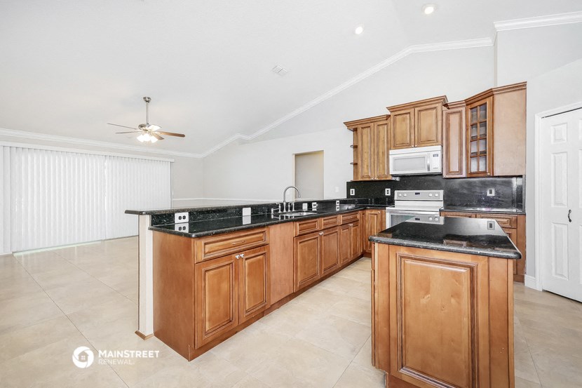 a large kitchen with wooden cabinets and black counter tops
