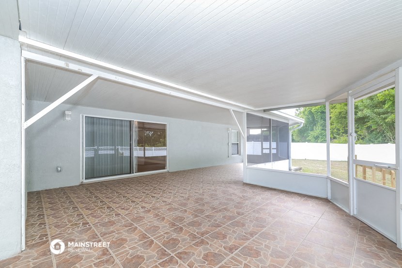 an empty living room with glass doors and a patio