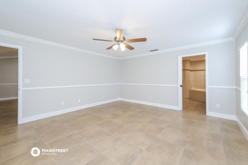 the living room of an empty house with a ceiling fan
