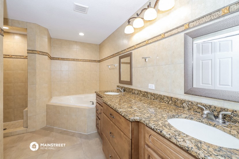 a bathroom with two sinks and a tub and a mirror