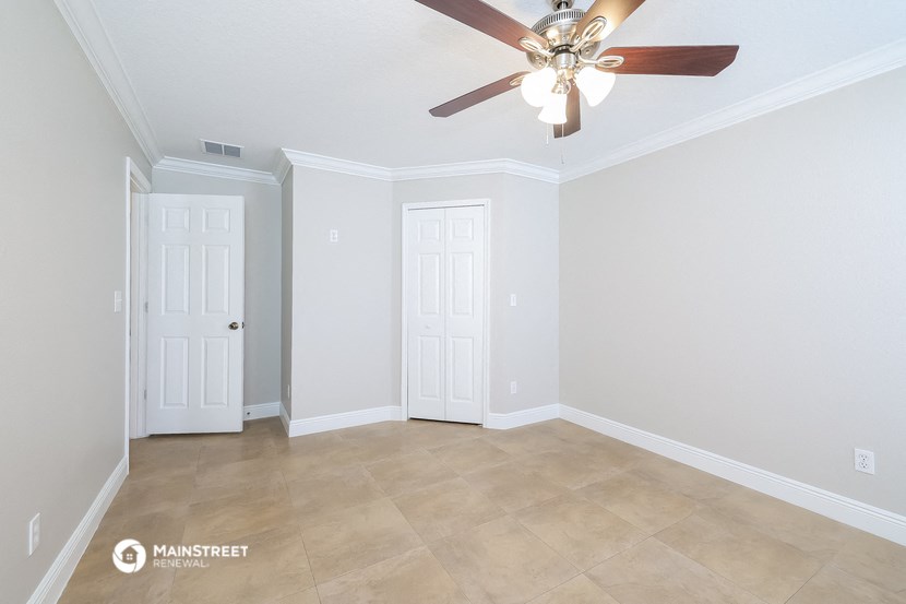 a empty living room with a ceiling fan