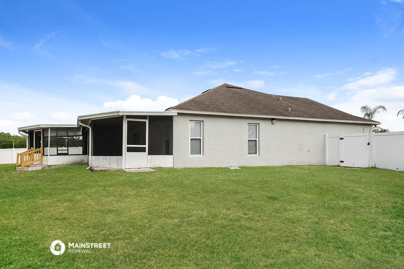 a white house with a grass yard and a white fence