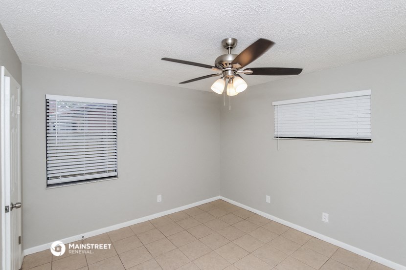 the living room has a ceiling fan and a tiled floor