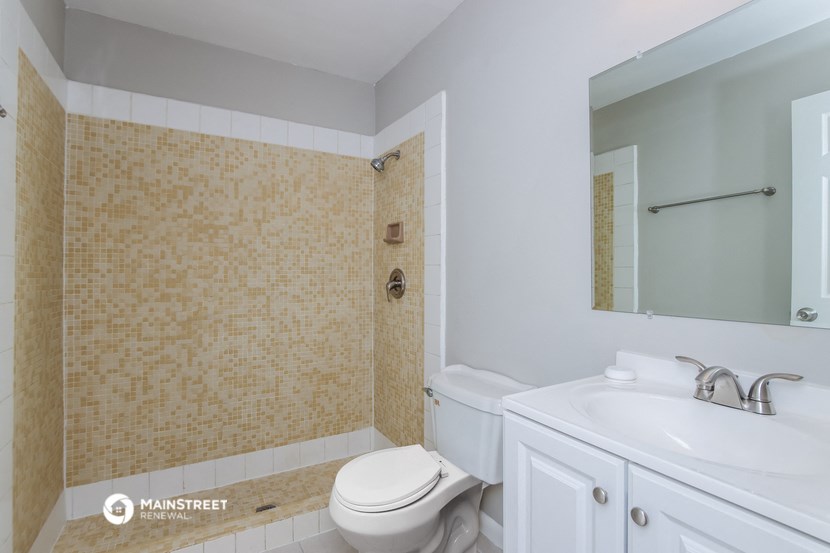 a bathroom with a toilet and a sink and a mirror